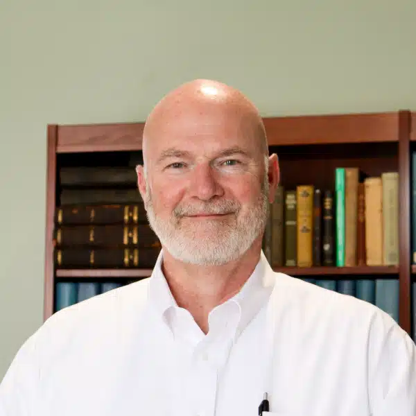 Photo of Board President Barry Steele in front of bookshelves
