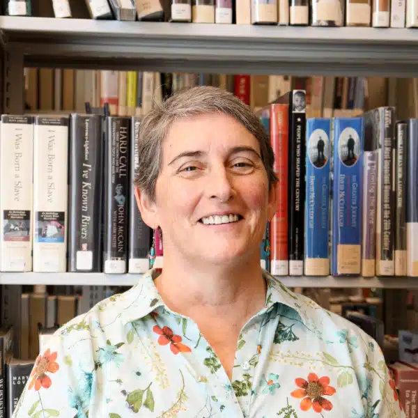 Photo of Board Vice President Tressa Brown in front of bookshelves.