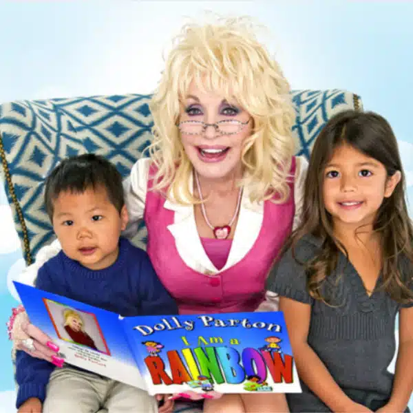 Dolly Parton reading to two children in an armchair